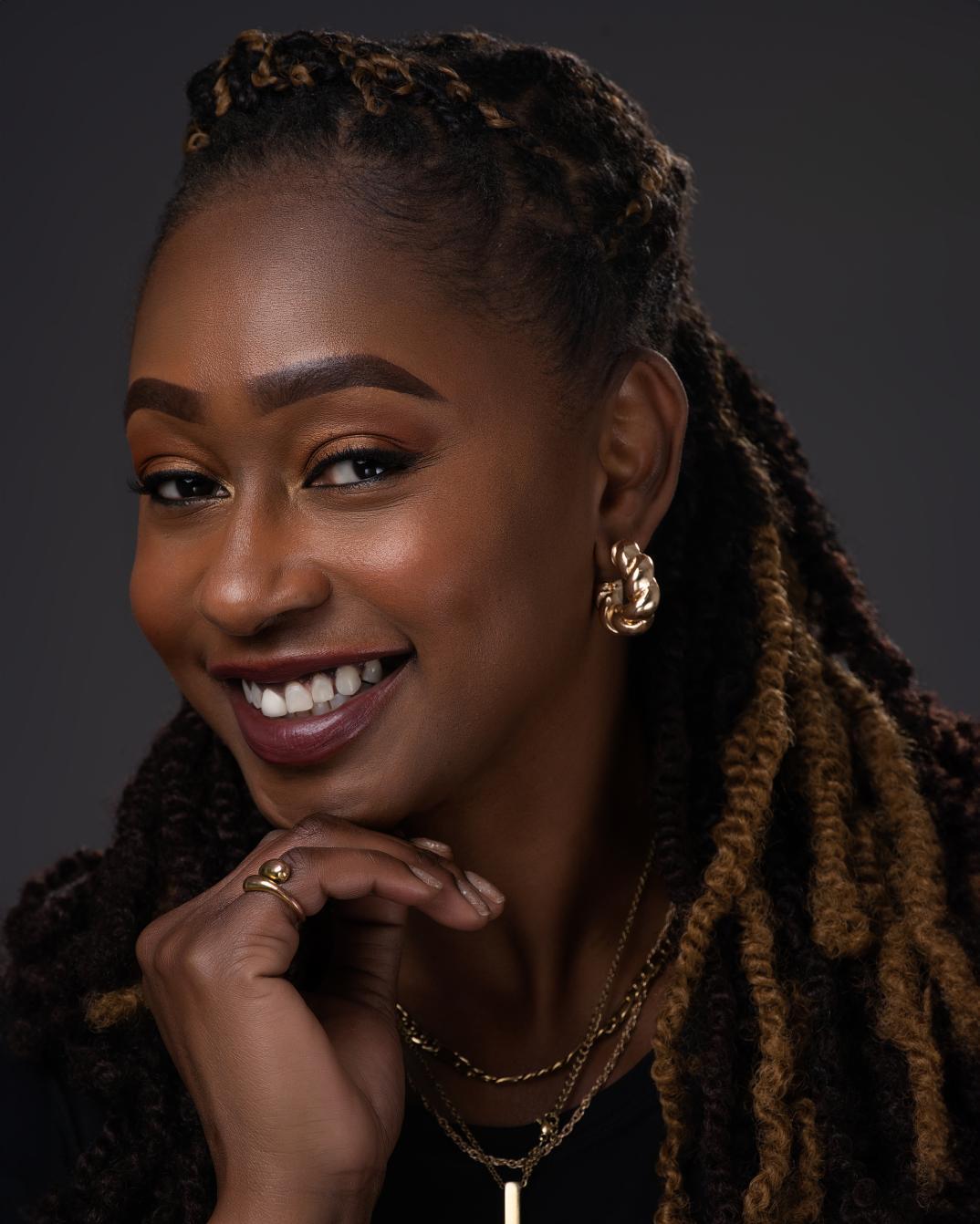 Smiling woman with dreadlocks and gold jewelry